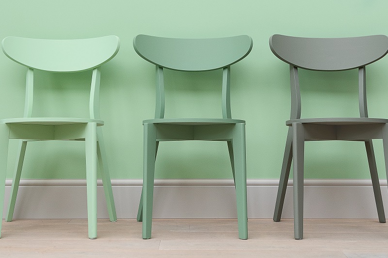 3 green chairs painted in front of a wall painted green